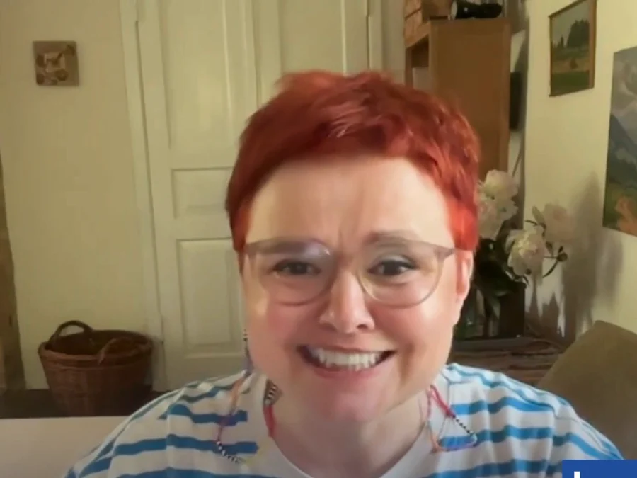 Oksana T., a Ukrainian learner, smiling on a video call from her home.
