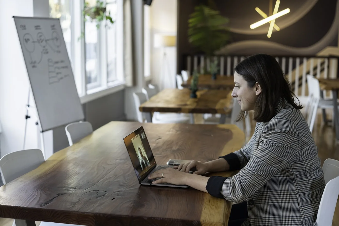 A woman in a live online lesson, smiling at her laptop