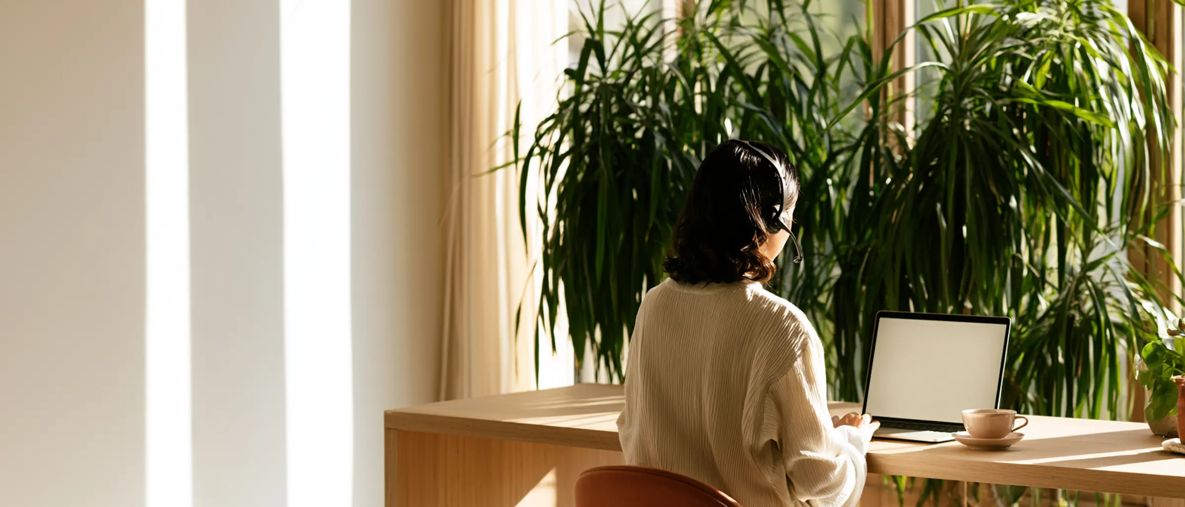 En deltaker ved et solfylt skrivebord, midt i en samtale