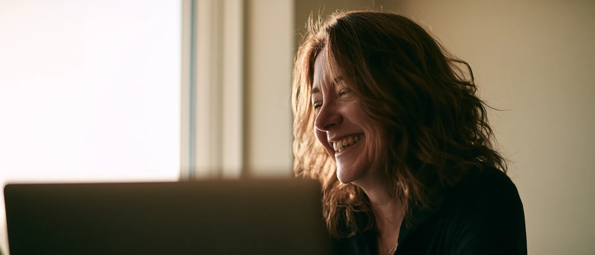 A woman laughing in the middle of a video session